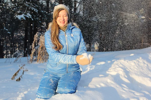The woman with long hair in a blue jacket swept up by snow