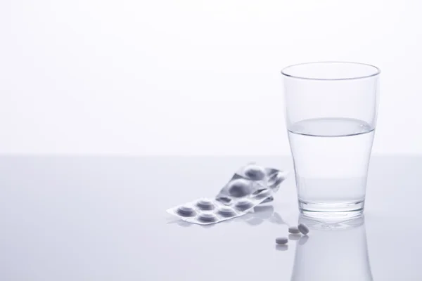 Glass of water and pills