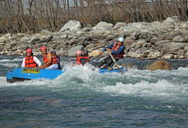 Manali, India - December 28, 2013: Tourists enjoy white water rafting in the Beas river in the Himalayas, Manali, India