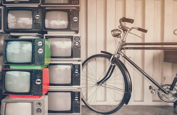 Bicycle and old TV on the retro yellow background. To illustrate