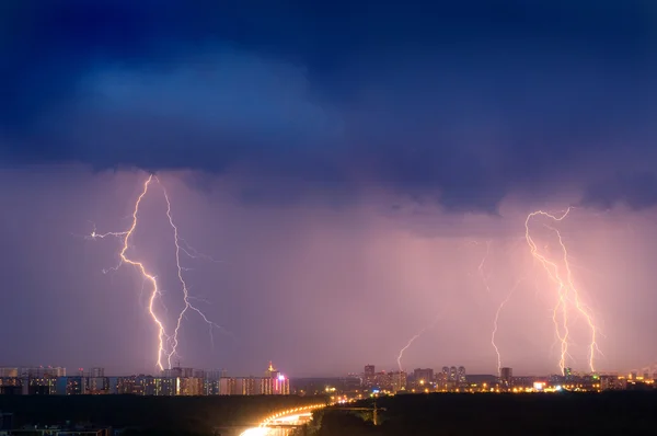 Lightning strike over city in purple light.