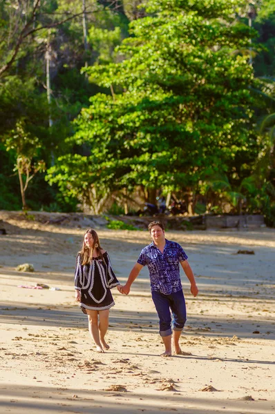 Joyful honeymoon couple playing on a beach