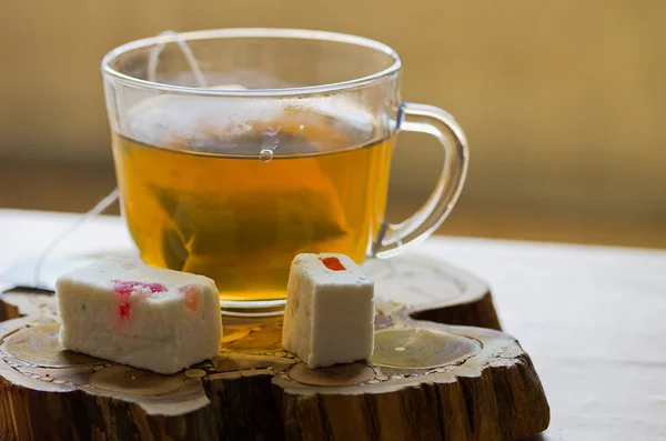 Cup of green tea and pastila with fruit jelly on a wooden stand