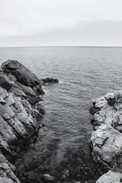 The rocky coastline. Rock in the sea. Black and white