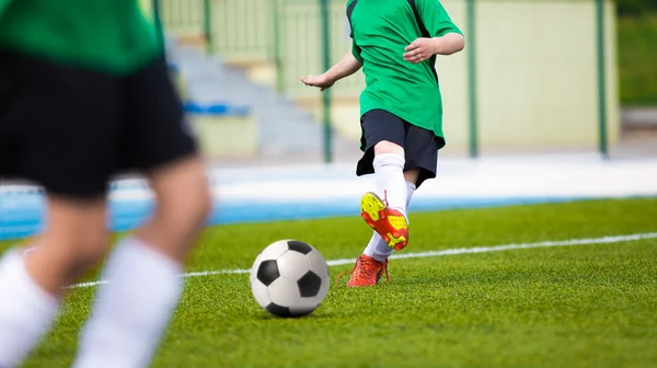 Football soccer kick. Young player kicking soccer ball