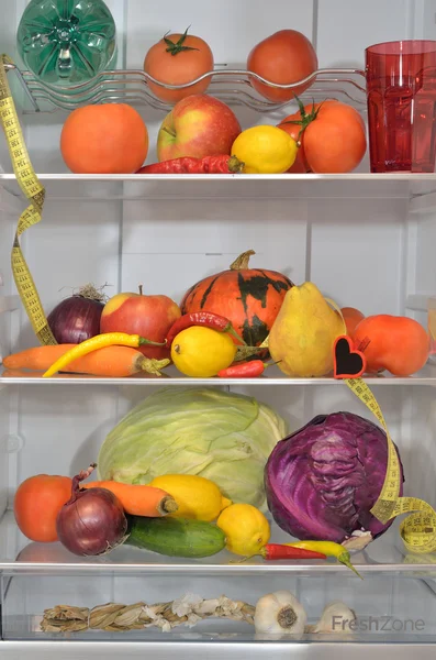 Refrigerator shelves with fruits, vegetables, water and measure