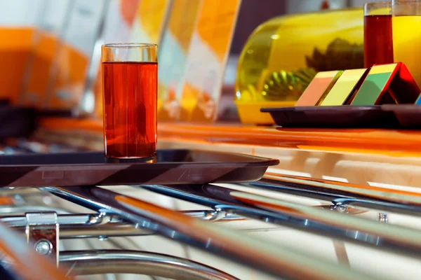 Closeup image of red cherry juice glass on tray at metal rack at fast food cafe background.