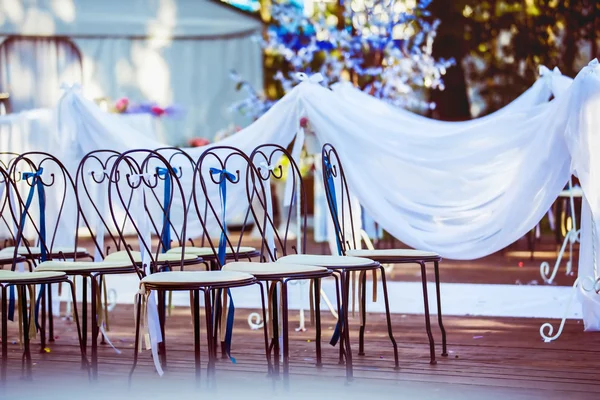Row of decorated chairs at a wedding ceremony at holiday background.