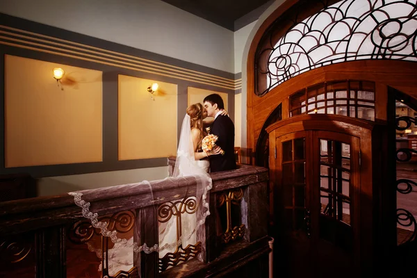 Beautiful wedding couple is kissing in classic vintage indoor in