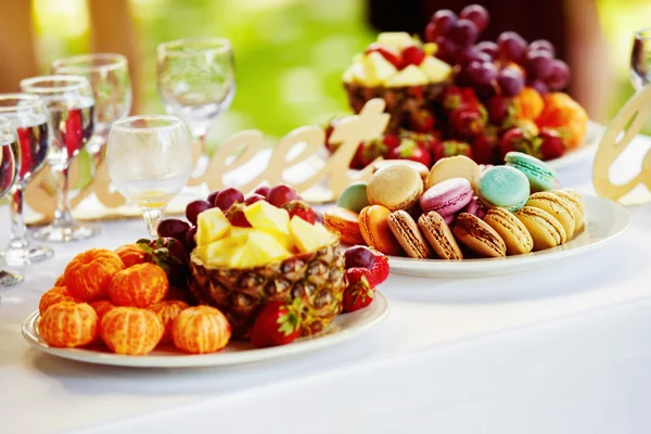Closeup image of fresh fruits and berries and cookies at a white table background.