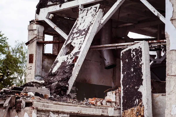 A closeup image of a ruined building with concrete and armature around. Concept of disaster, war. Retreat for homeless.