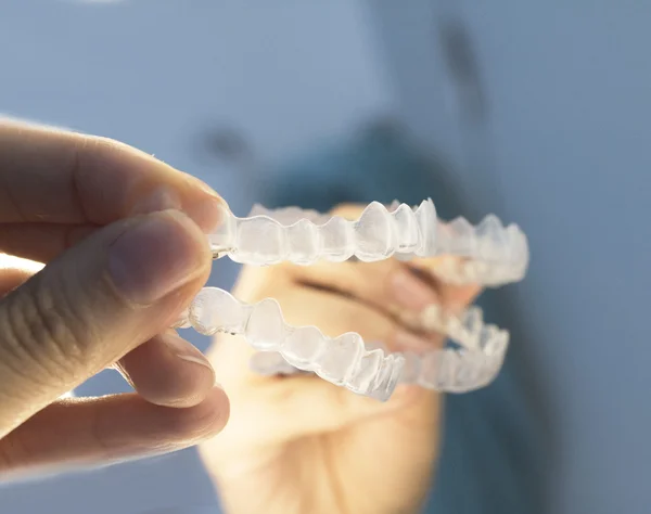Woman hand holding  invisible dental braces
