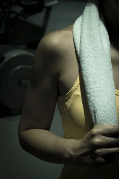 Woman in gym with towel on the neck