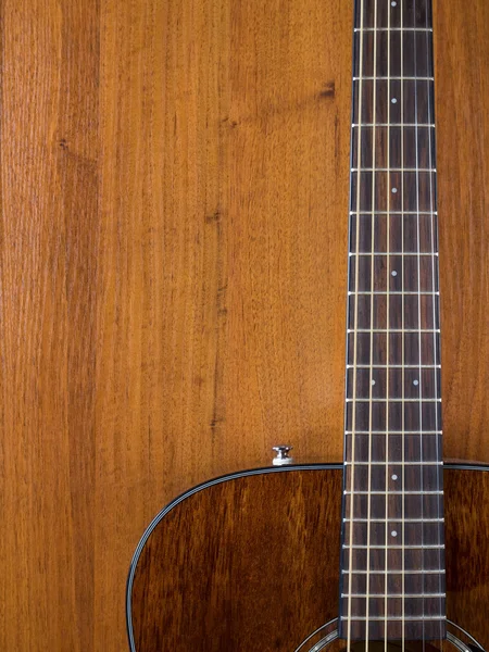 Acoustic guitar leaning against the wooden wall