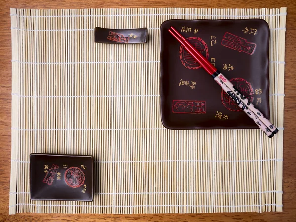 Bamboo mat, plates and chopstick on the table