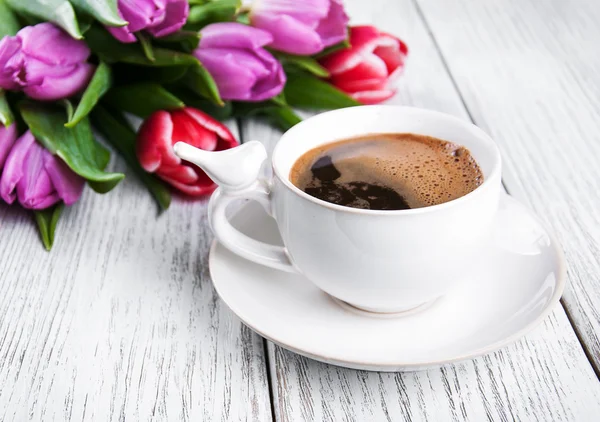 Cup of coffee with tulips
