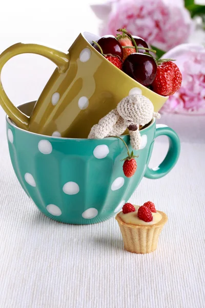Teddy bear in a cup with berries