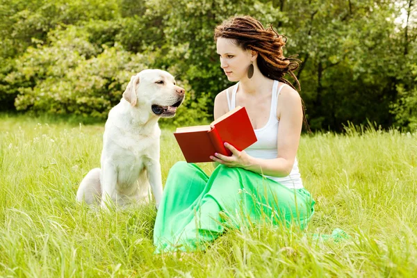 Student girl with the book teaches the dog. Animal rights