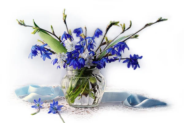 Blue flowers in spring water in a glass vase.