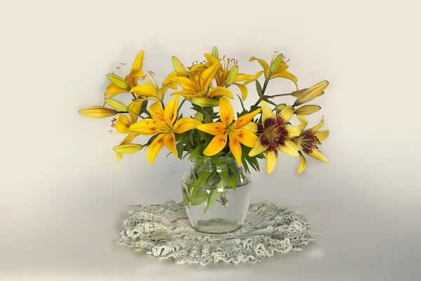 Still life with lilies in a vase with water.