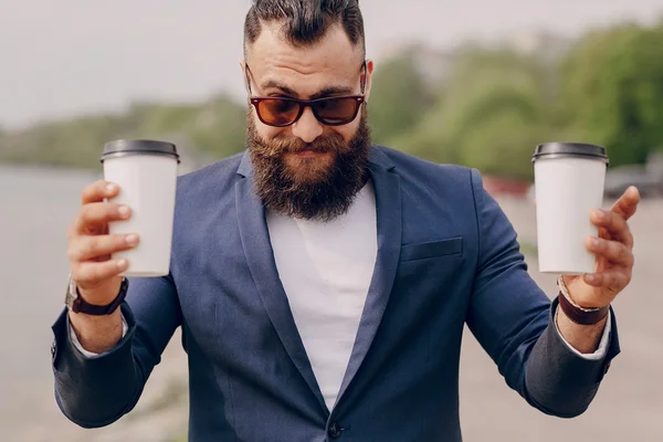 Bearded man carrying coffee