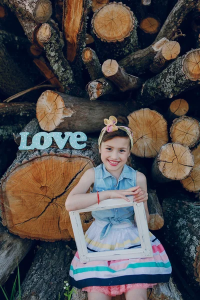 Beautiful little girl sitting on trees