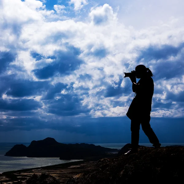 Woman silhouette standing on top of his photography.