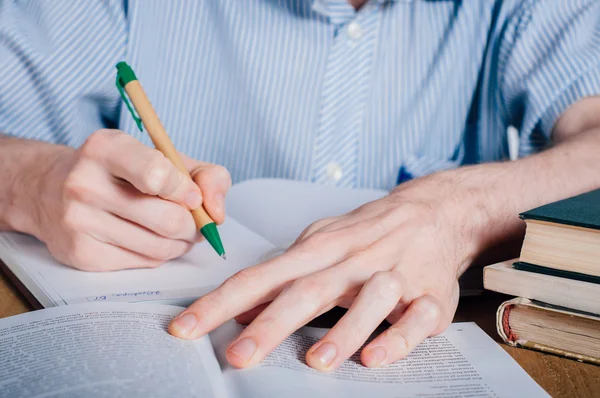 Young man writing in organizer