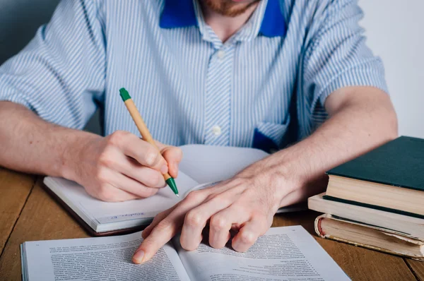 Young man writing in organizer