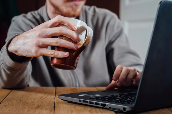 Young man working with laptop and coffee