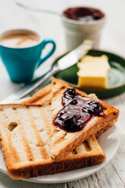 Breakfast with coffee, toasts, butter and jam