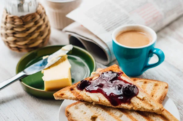 Breakfast with coffee, toasts, butter and jam