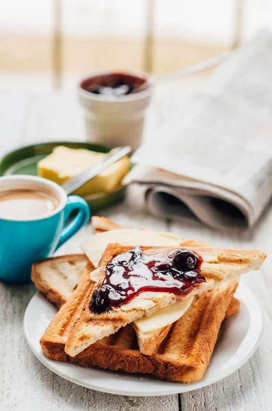 Breakfast with coffee, toasts, butter and jam