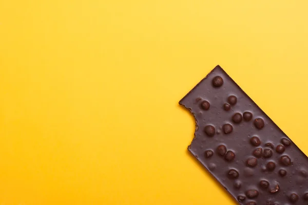 Chocolate bar with nuts on yellow