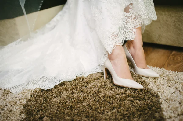 Bride getting dressed shoes on her wedding day