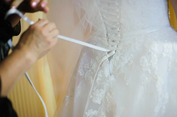 Bride getting dressed on her wedding day