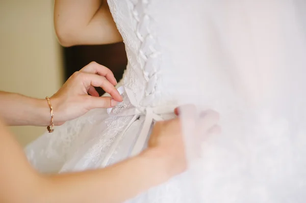 Bride getting dressed on her wedding day