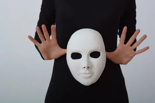 White theatrical mask in her hands.on white background