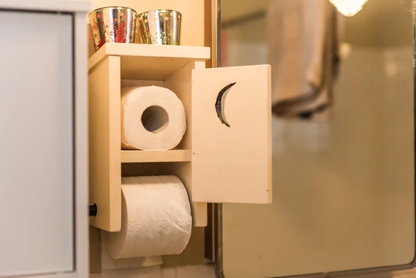 Wooden bathroom toilet paper dispenser and holder with crescent moon door.  Even in the bathroom, paperwork is never done.