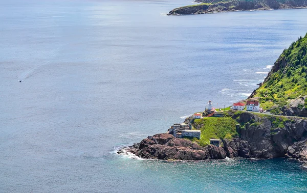 Rugged coastline and Atlantic ocean. Warm summer day in August.  Views from atop historically famous Signal Hill in St. John\'s. A speeding boat passing through appears slow relative to the vastness.