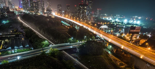 Glowing light streaks along the Gardiner Expressway on a hot & muggy summer night in Lakeside Toronto, Canada.