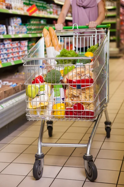 Woman shopping with her trolley full of products