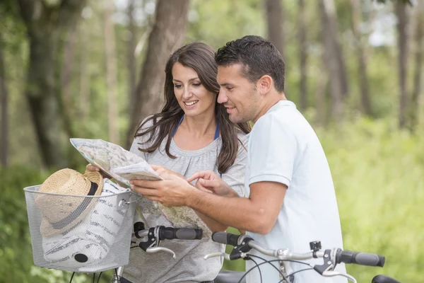 Young couple with map and bike