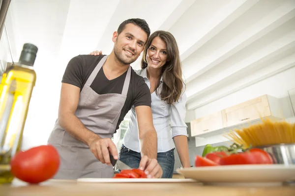 Young couple in kitchen prearing lunch