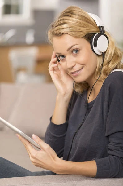 Young woman listening music with digital tablet at home