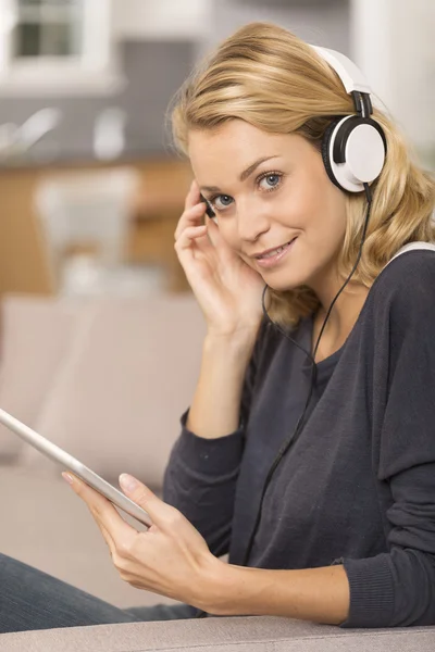 Young woman listening music with digital tablet at home