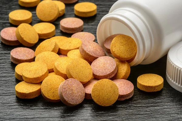 Vitamin and mineral pills on black background.