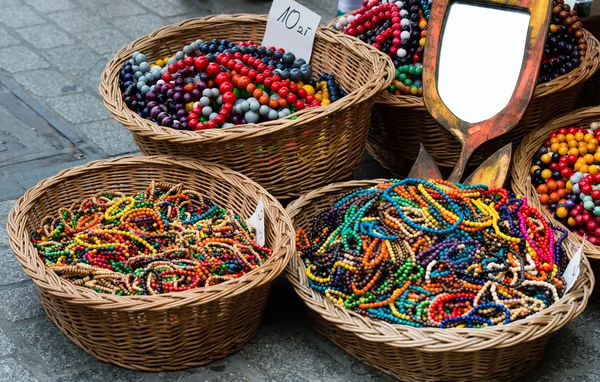The baskets with colorful wooden beads on the street market.