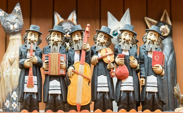 The variety of wooden handmade souvenirs -figurines of cats and jewish musicians.