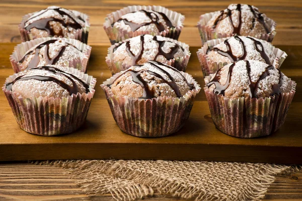 Chocolate muffins on the wooden board.